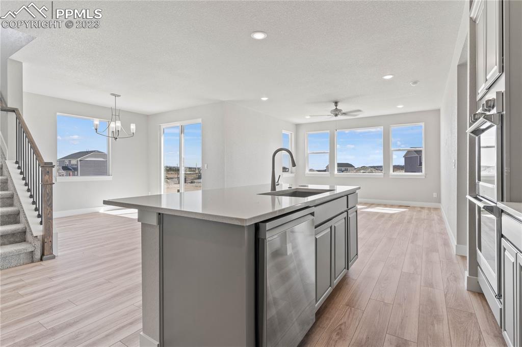 2155 Coyote Mint Drive Monument, CO 80132 - Photo 9 of 45 a kitchen with stainless steel appliances granite countertop a sink stove and wooden floor