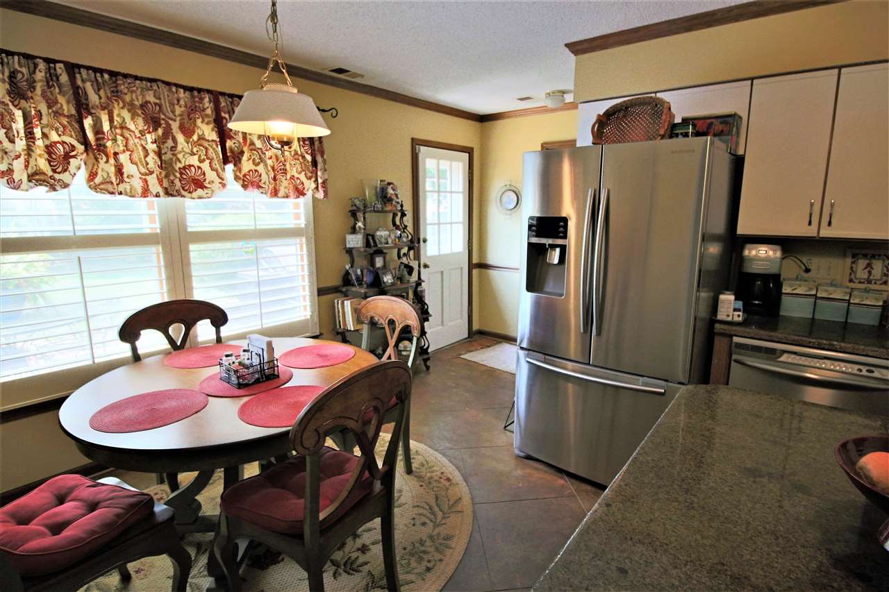 8541 Bazemore Road Memphis, TN 38018 - Photo 8 of 24 a kitchen with stainless steel appliances granite countertop sink refrigerator dining table and chairs
