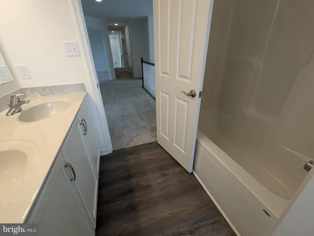 a view of a room with wooden floor and white walls