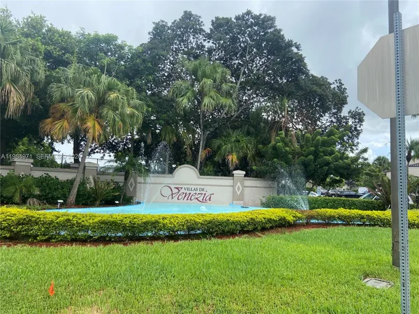 a view of a swimming pool with a bench and trees around