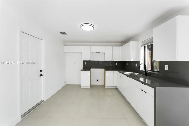 a view of an empty room with a kitchen