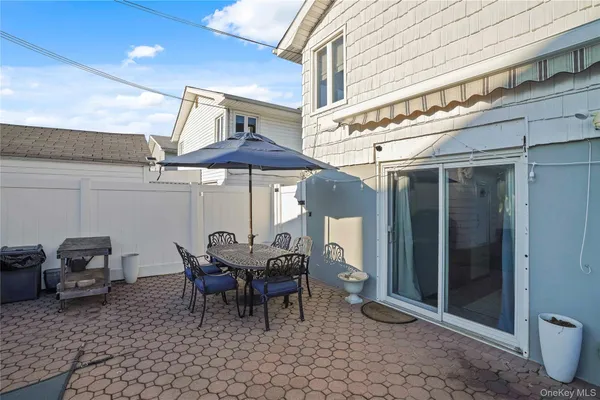 a view of a patio with a table and chairs under an umbrella
