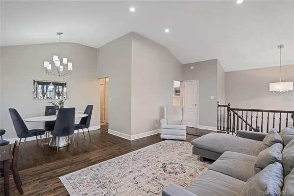 a living room with furniture and a dining table with wooden floor