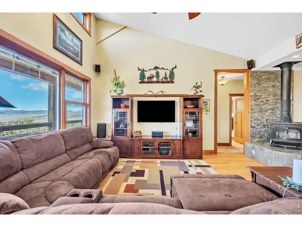 a living room with furniture flat screen tv and a large window