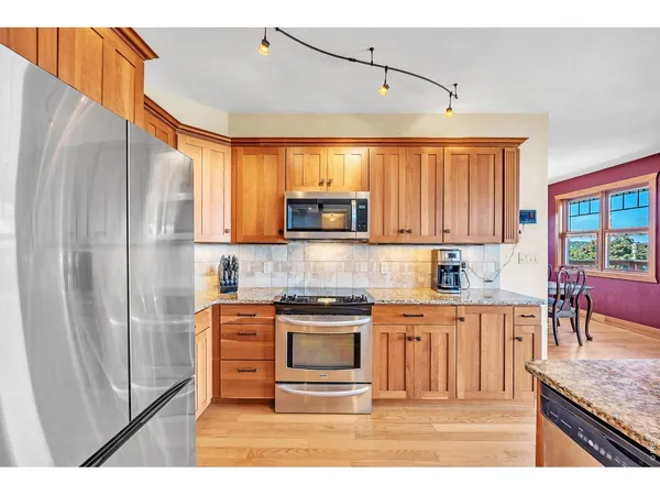 a kitchen with stainless steel appliances granite countertop a refrigerator and a stove top oven