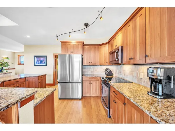 a kitchen with stainless steel appliances granite countertop a sink refrigerator and cabinets