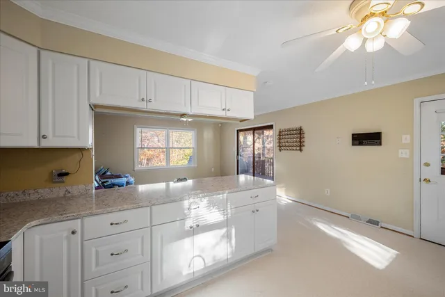 a kitchen with stainless steel appliances granite countertop a refrigerator a stove a sink dishwasher and a fireplace with wooden floor