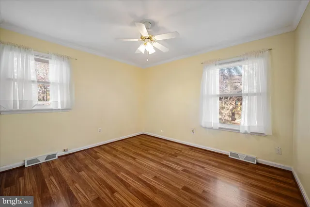 a view of a room with wooden floor and a ceiling fan