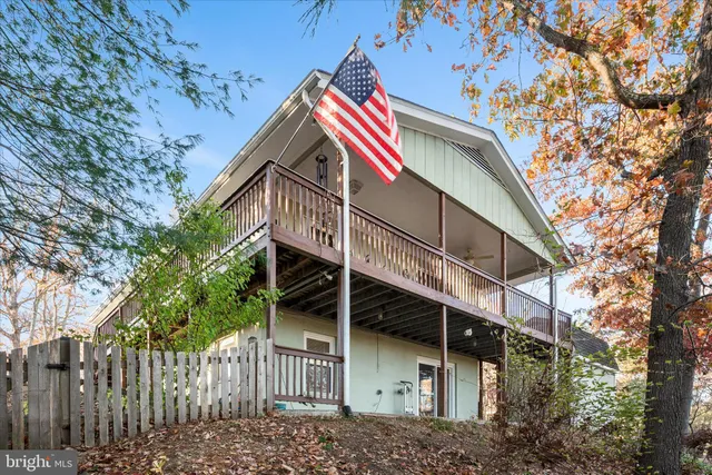 a view of a house with a small yard and wooden fence