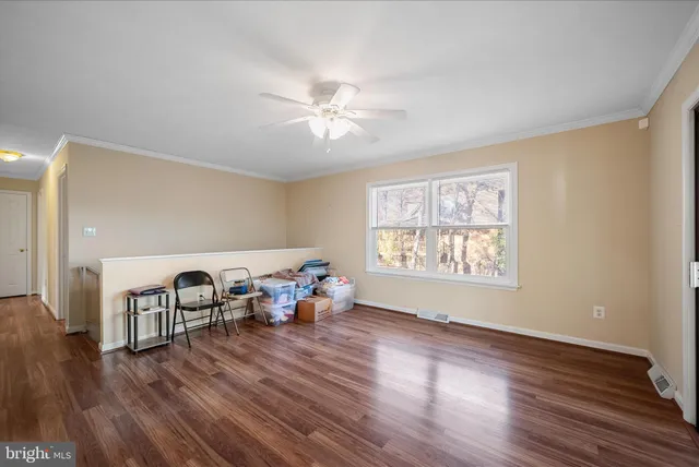 a view of an empty room with window and wooden floor