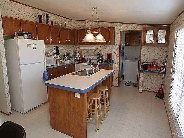 199 Maple Road Angier, NC 27501 - Photo 3 of 8 a kitchen that has a cabinets a sink and a refrigerator