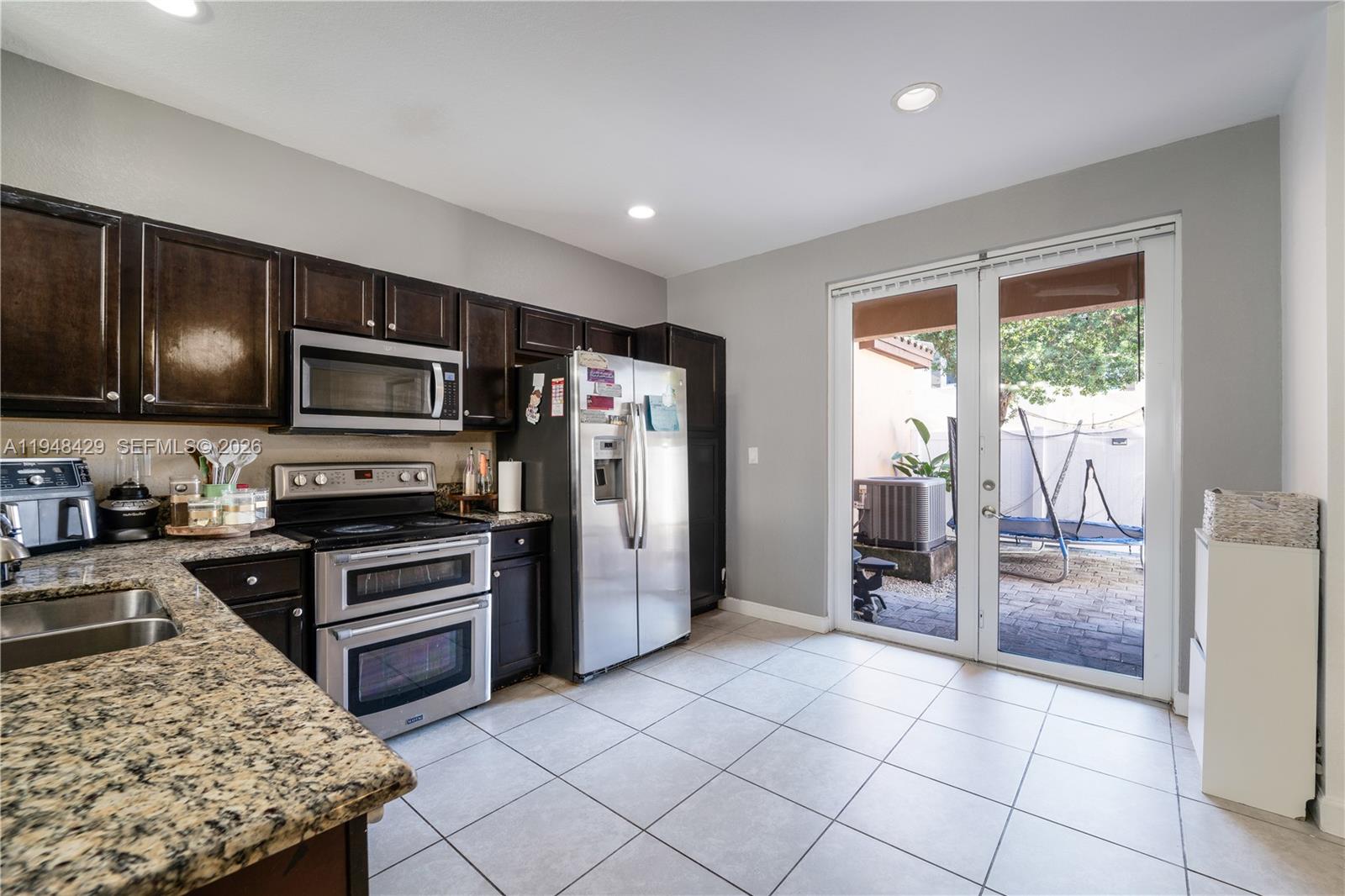 9360 Southwest 171st Court Miami, FL 33196 - Photo 16 of 43 a kitchen with stainless steel appliances granite countertop a refrigerator and a stove top oven