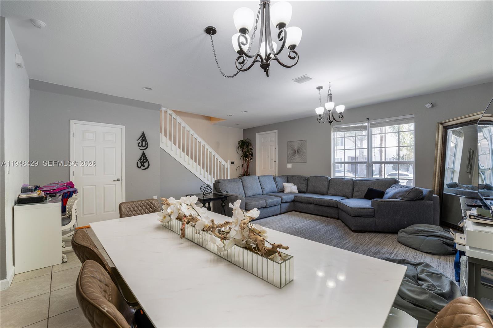 9360 Southwest 171st Court Miami, FL 33196 - Photo 10 of 43 a living room with furniture chandelier and kitchen view