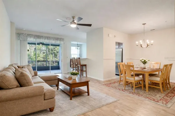 a living room with furniture a chandelier and a dining table
