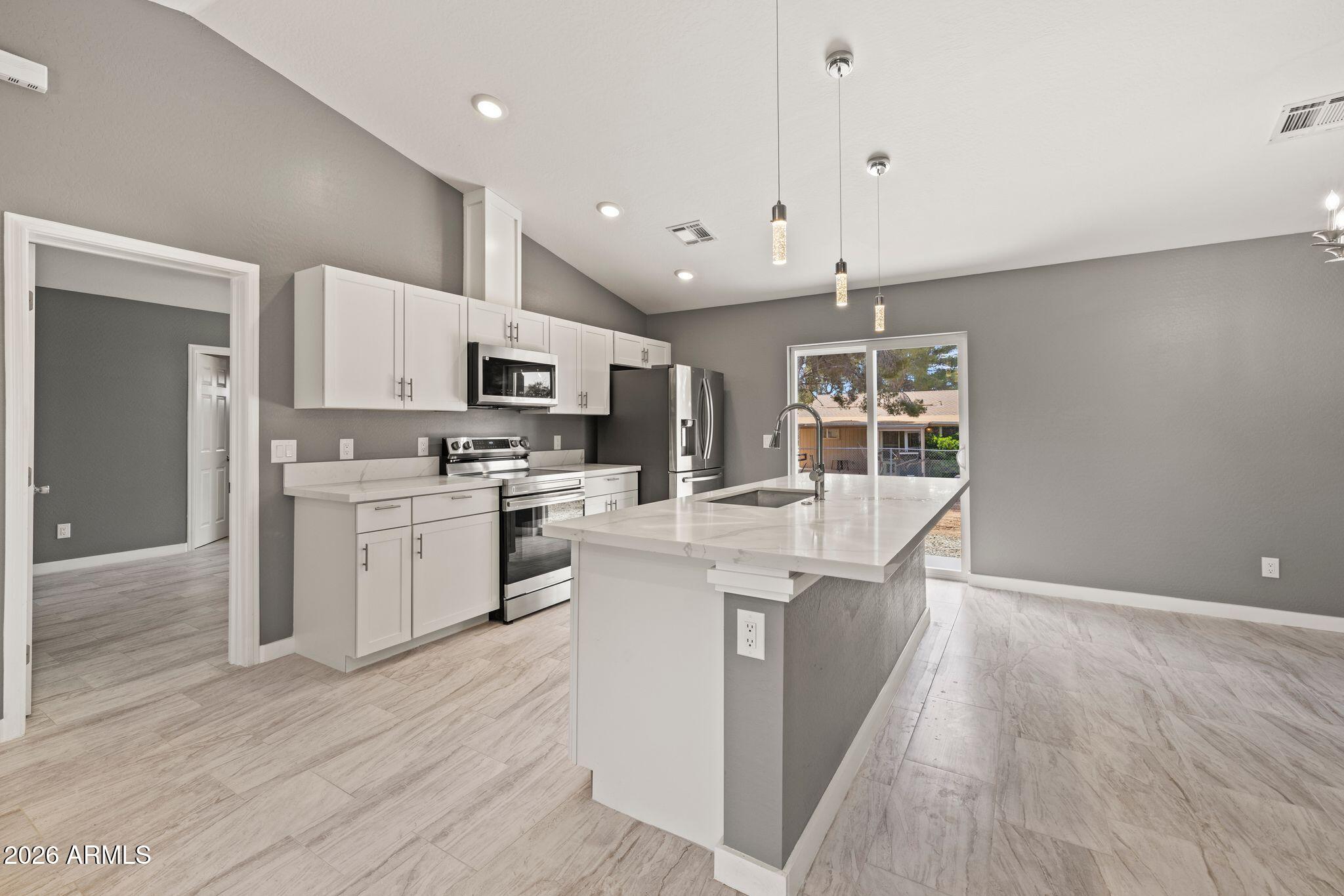 17933 East Bob White Road Mayer, AZ 86333 - Photo 11 of 30 a large kitchen with stainless steel appliances kitchen island a large counter top and wooden floors