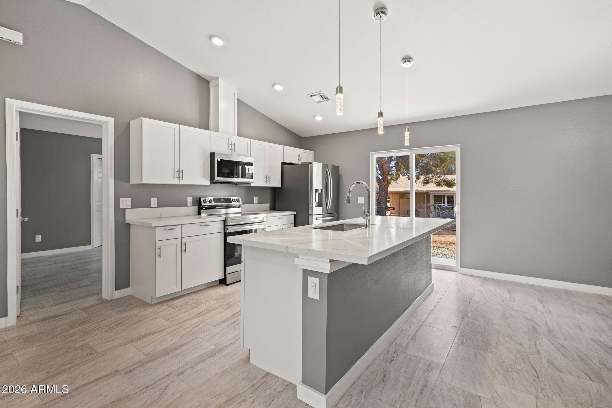 17933 East Bob White Road Mayer, AZ 86333 - Photo 12 of 30 a large kitchen with stainless steel appliances kitchen island granite countertop a stove a sink and a white refrigerator