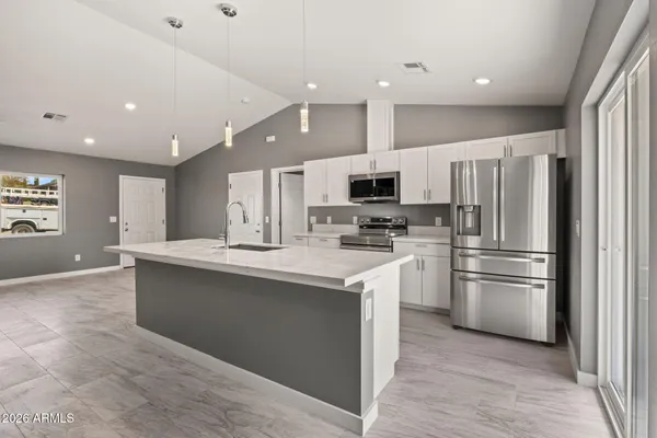 a kitchen with kitchen island a sink stainless steel appliances and cabinets