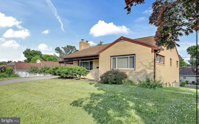 a view of a house with a yard and potted plants