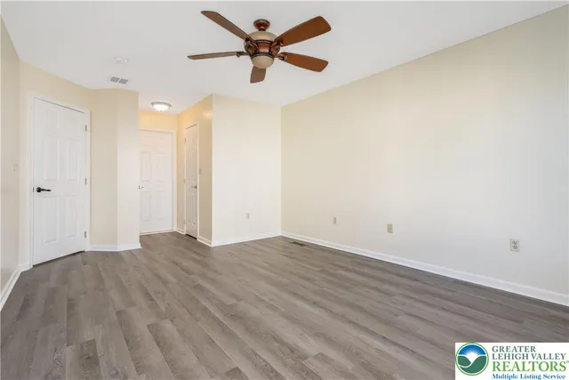 a view of a big room with wooden floor a ceiling fan and closet