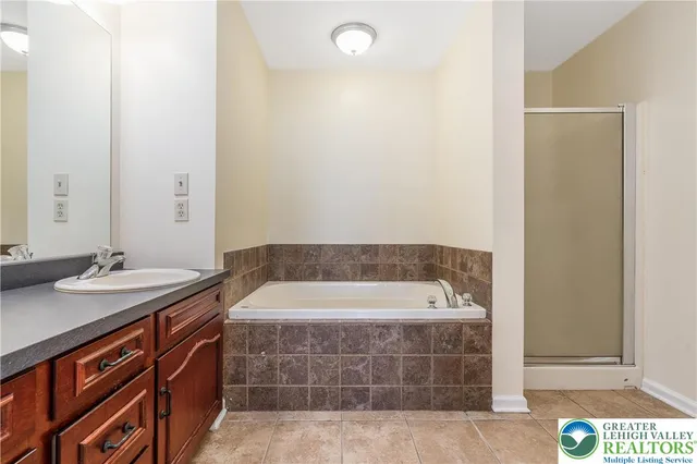 a bathroom with a tub a sink and a mirror