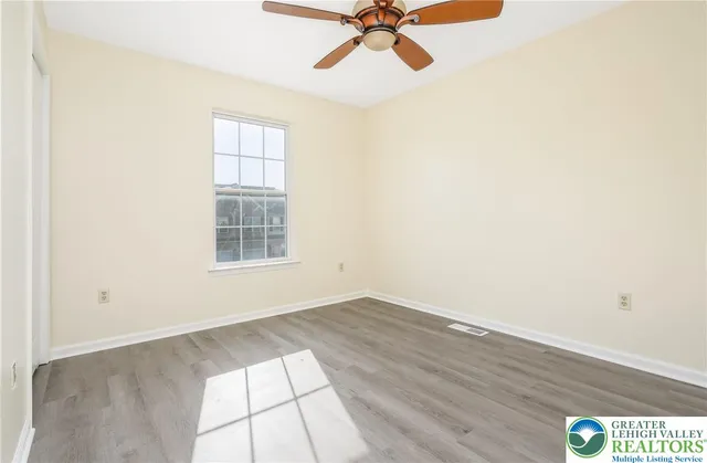 an empty room with a window and a fan