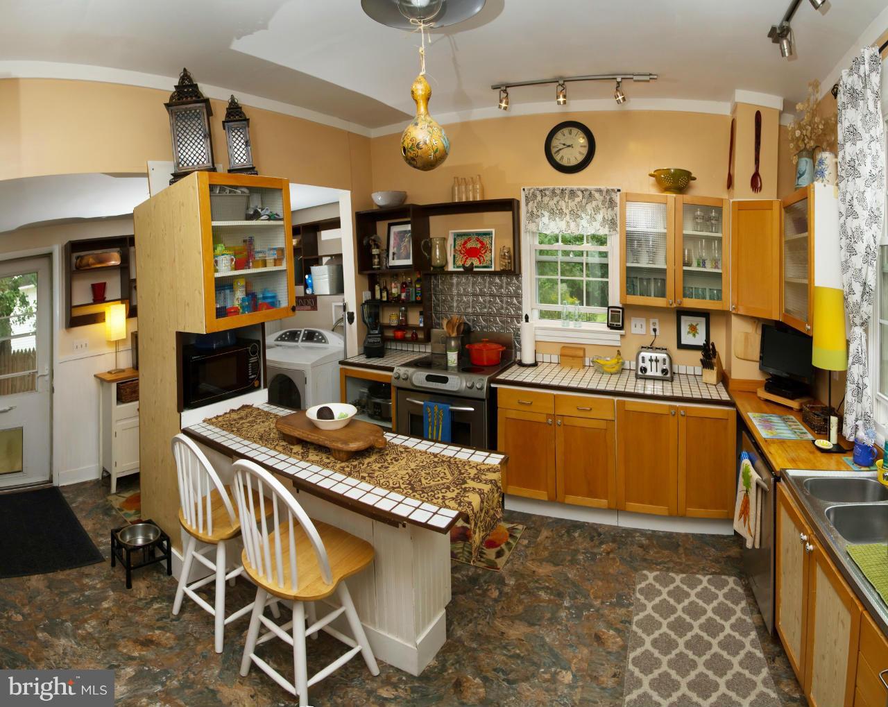 5719 Berwyn Road Berwyn Heights, MD 20740 - Photo 24 of 30 a dining room with stainless steel appliances granite countertop a stove and a dining table with chandelier