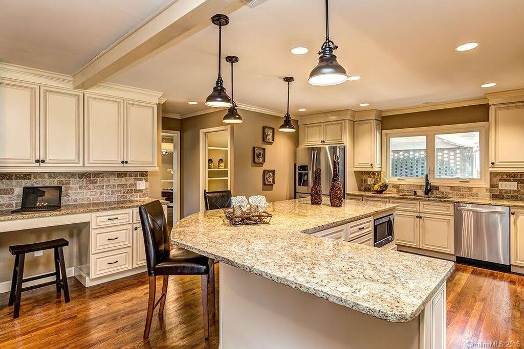 6127 Glenridge Road Charlotte, NC 28211 - Photo 1 of 24 a kitchen with stainless steel appliances granite countertop stove a sink and dishwasher wooden cabinets with wooden floor
