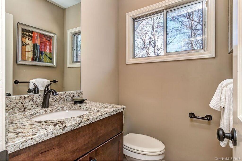6127 Glenridge Road Charlotte, NC 28211 - Photo 15 of 24 a bathroom with a granite countertop sink a toilet and a window