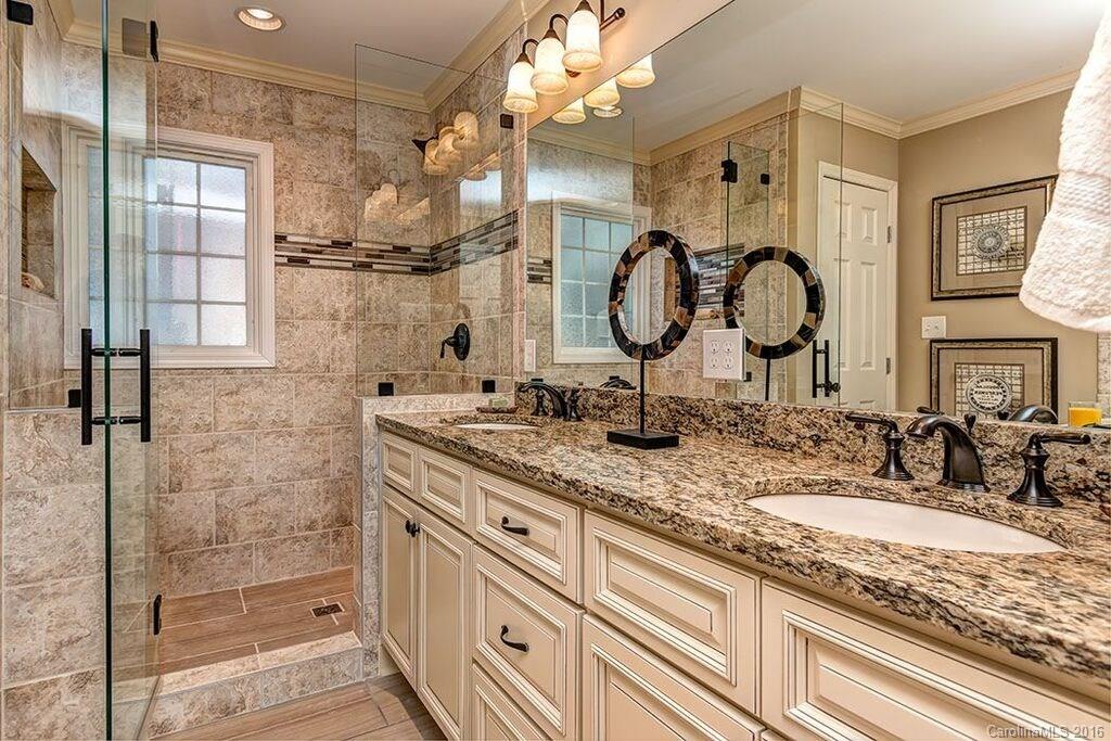 6127 Glenridge Road Charlotte, NC 28211 - Photo 20 of 24 a bathroom with a granite countertop sink a mirror and shower