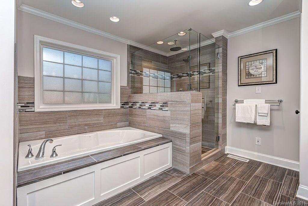 6127 Glenridge Road Charlotte, NC 28211 - Photo 24 of 24 a spacious bathroom with a granite countertop tub sink and mirror