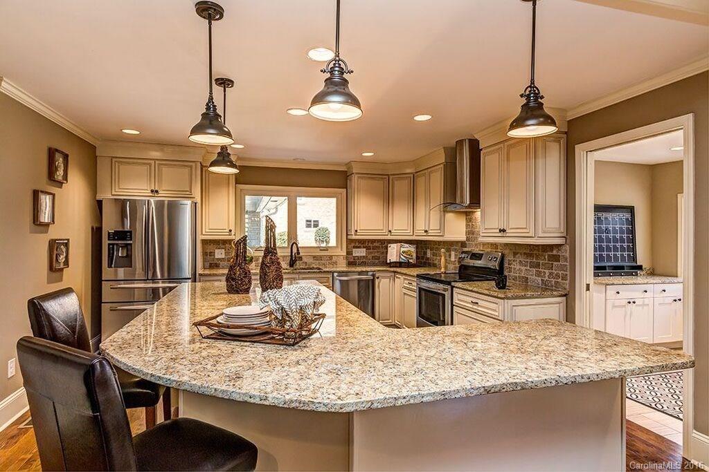 6127 Glenridge Road Charlotte, NC 28211 - Photo 9 of 24 a kitchen with stainless steel appliances granite countertop a sink a stove a refrigerator cabinets and chairs
