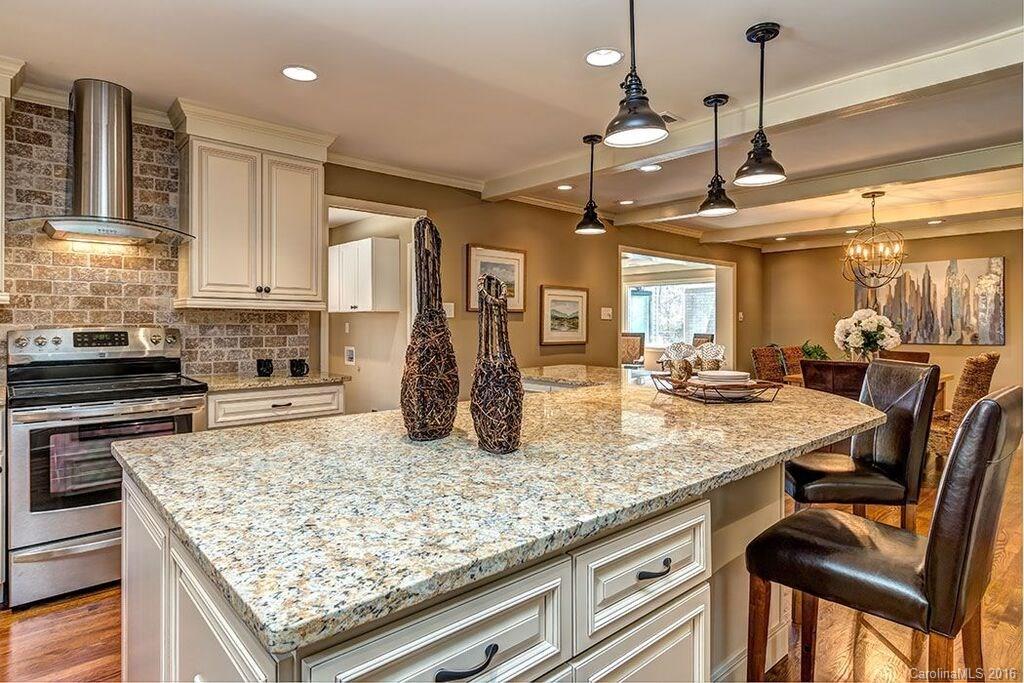 6127 Glenridge Road Charlotte, NC 28211 - Photo 10 of 24 a kitchen with stainless steel appliances granite countertop sink stove top oven and cabinets