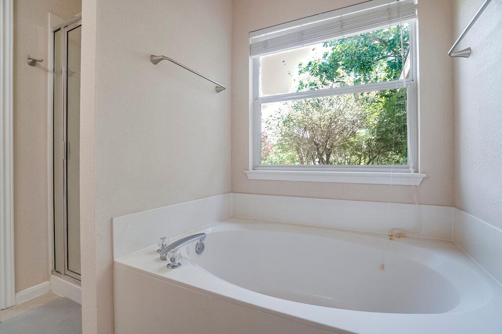 2724 Kickapoo Cavern Drive Pflugerville, TX 78660 - Photo 15 of 24 Indulge in relaxation with this inviting soaking tub, perfectly positioned by a window offering verdant outdoor views.