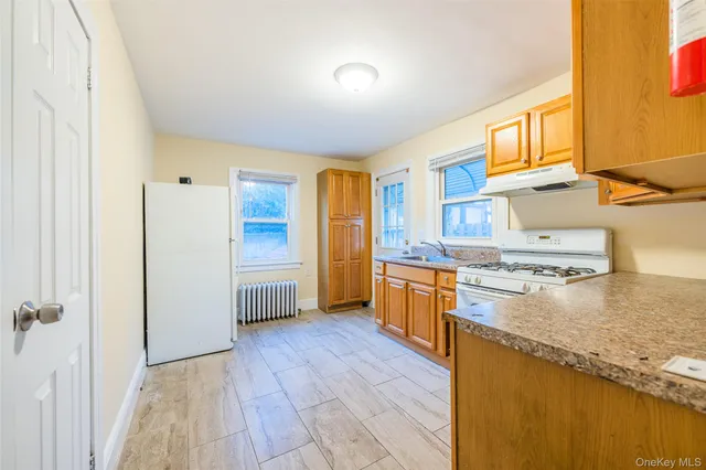 a kitchen with stainless steel appliances granite countertop a refrigerator a stove and a wooden floors