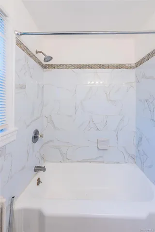 a bathroom with a bathtub and a shower