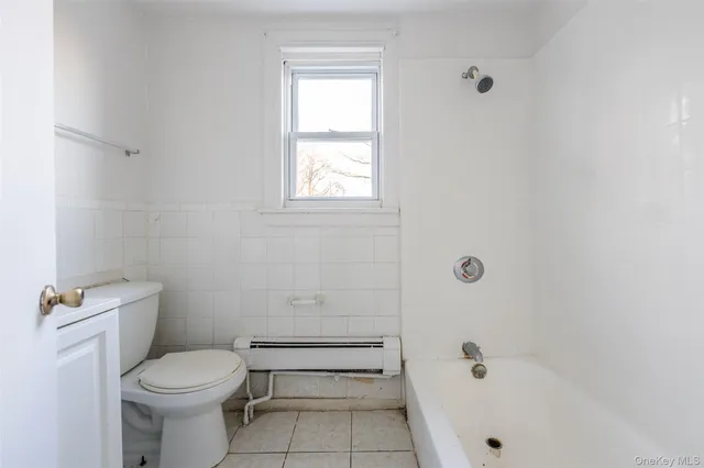 a white toilet sitting next to a bath tub