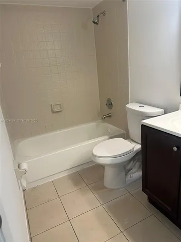 a white toilet and tub sitting next to a bathroom sink