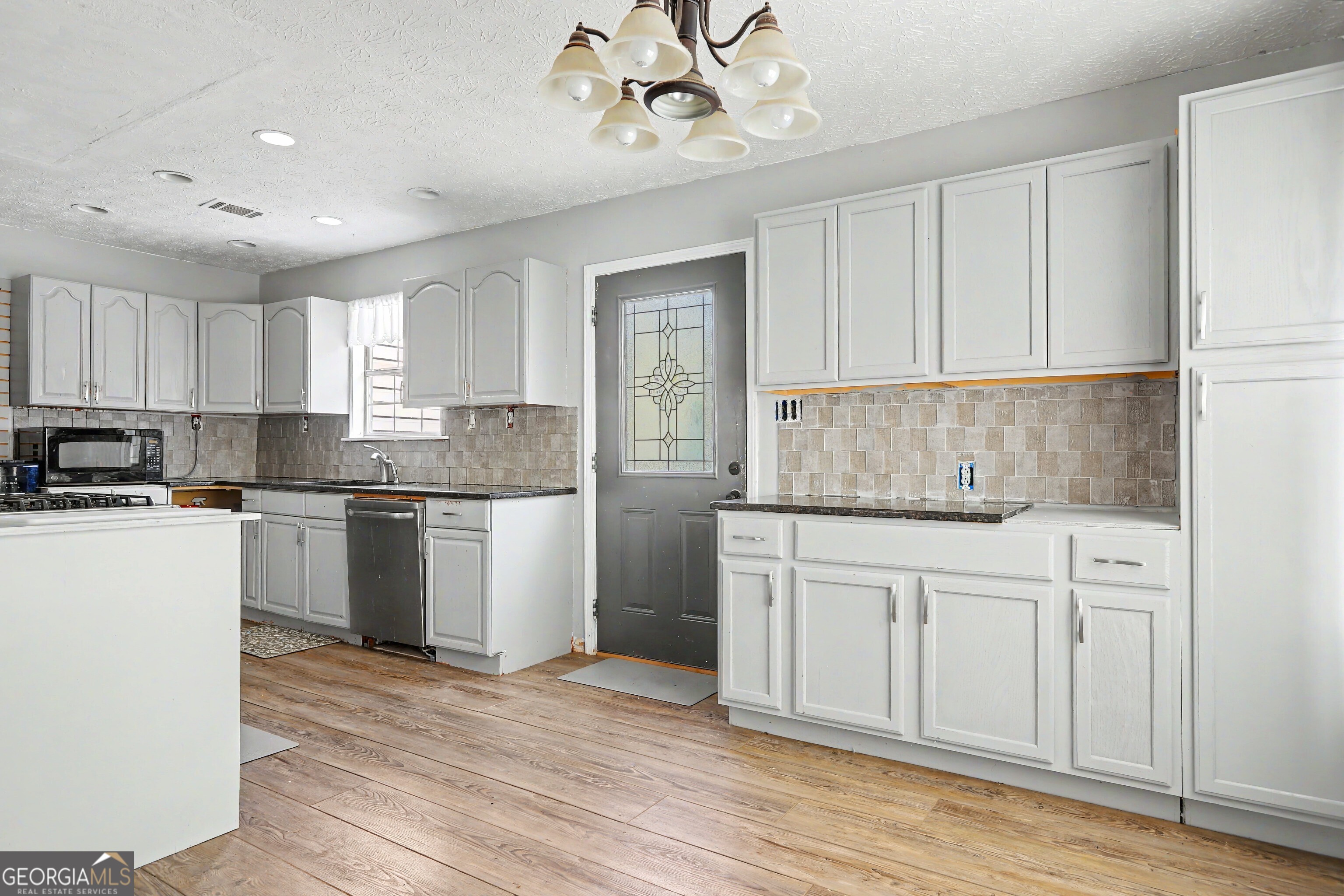 376 Doe Lane Mansfield, GA 30055 - Photo 14 of 28 a kitchen with granite countertop white cabinets and white appliances
