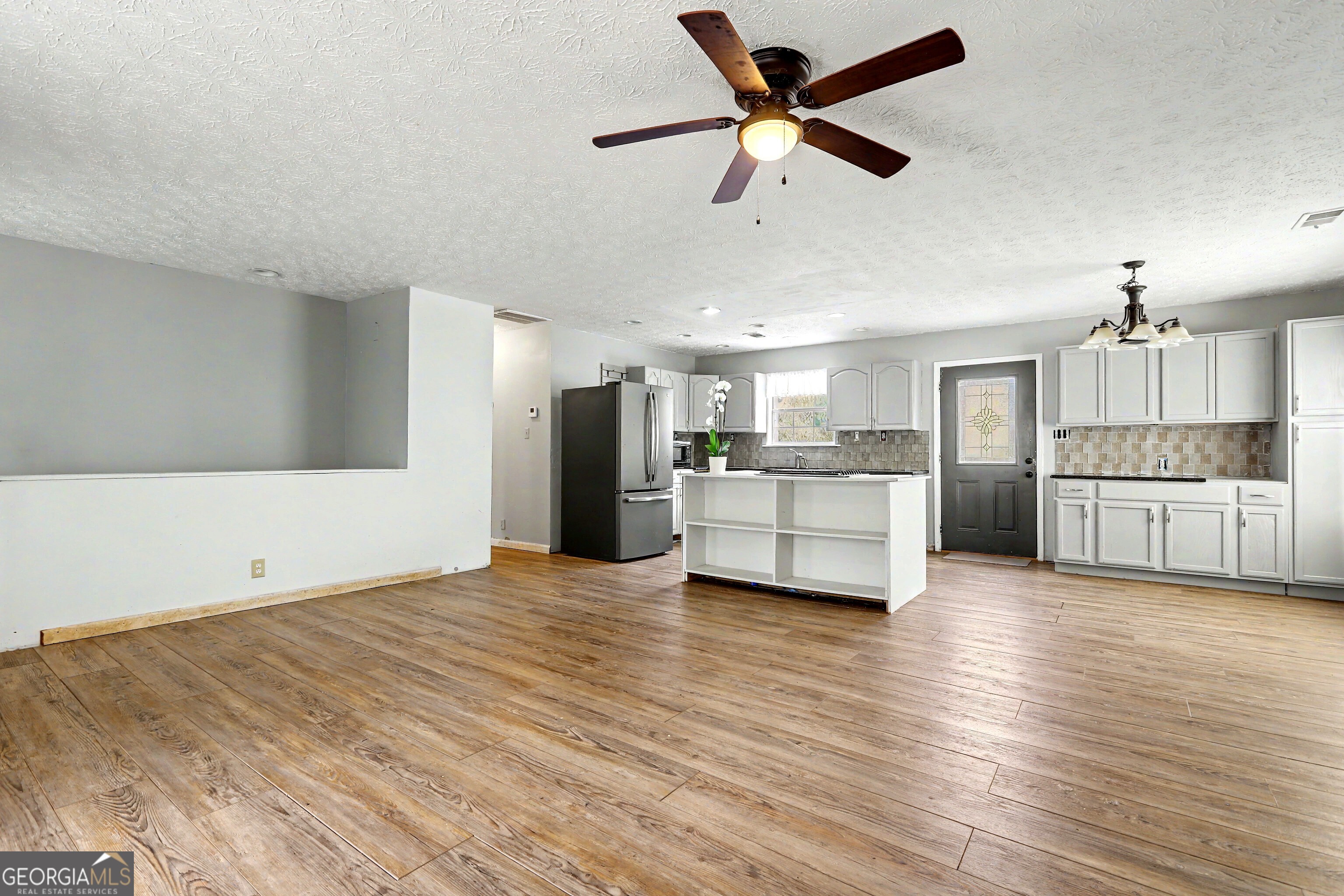 376 Doe Lane Mansfield, GA 30055 - Photo 5 of 28 a view of a kitchen with a stove cabinets a ceiling fan and wooden floor