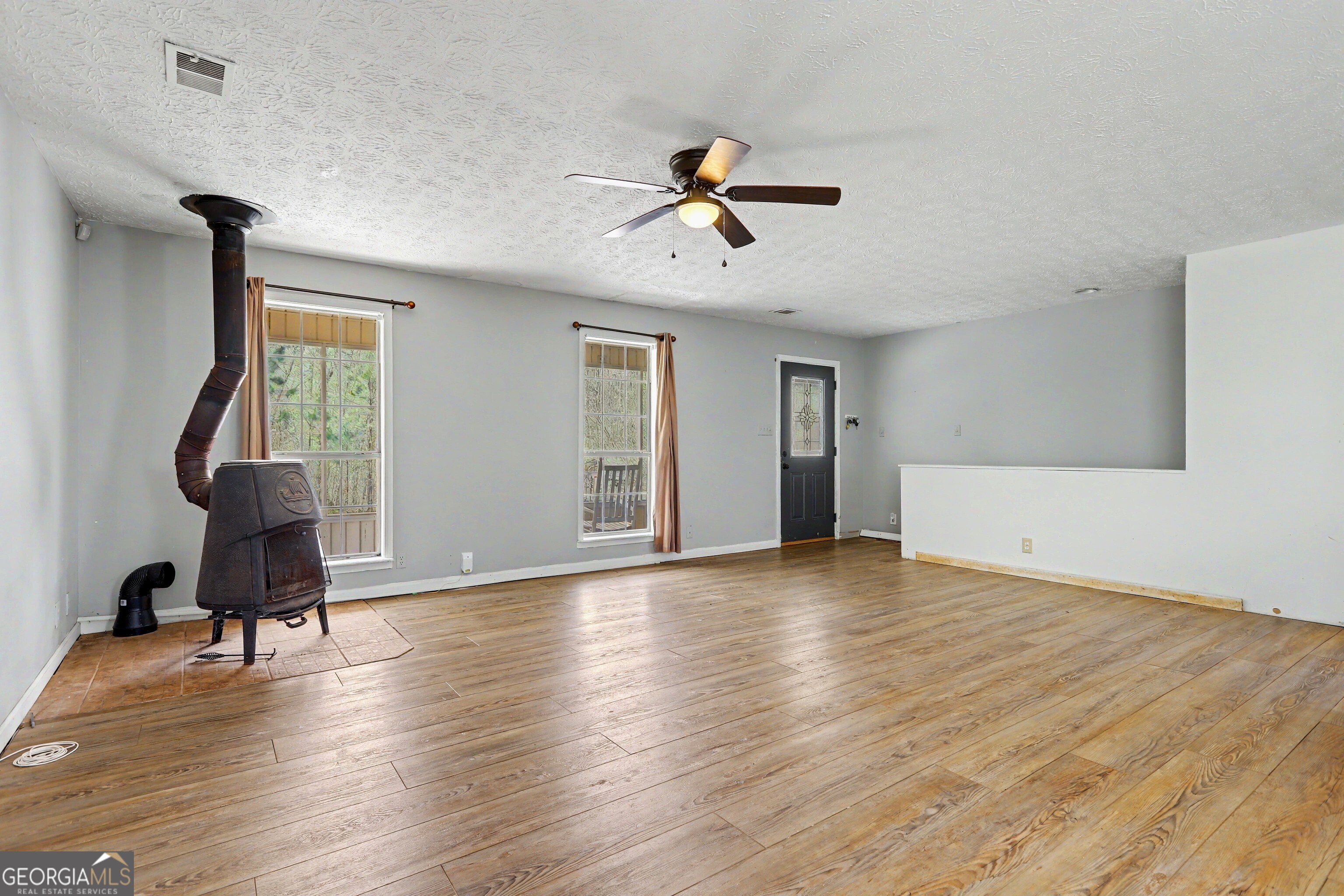 376 Doe Lane Mansfield, GA 30055 - Photo 7 of 28 a view of empty room with wooden floor and fan