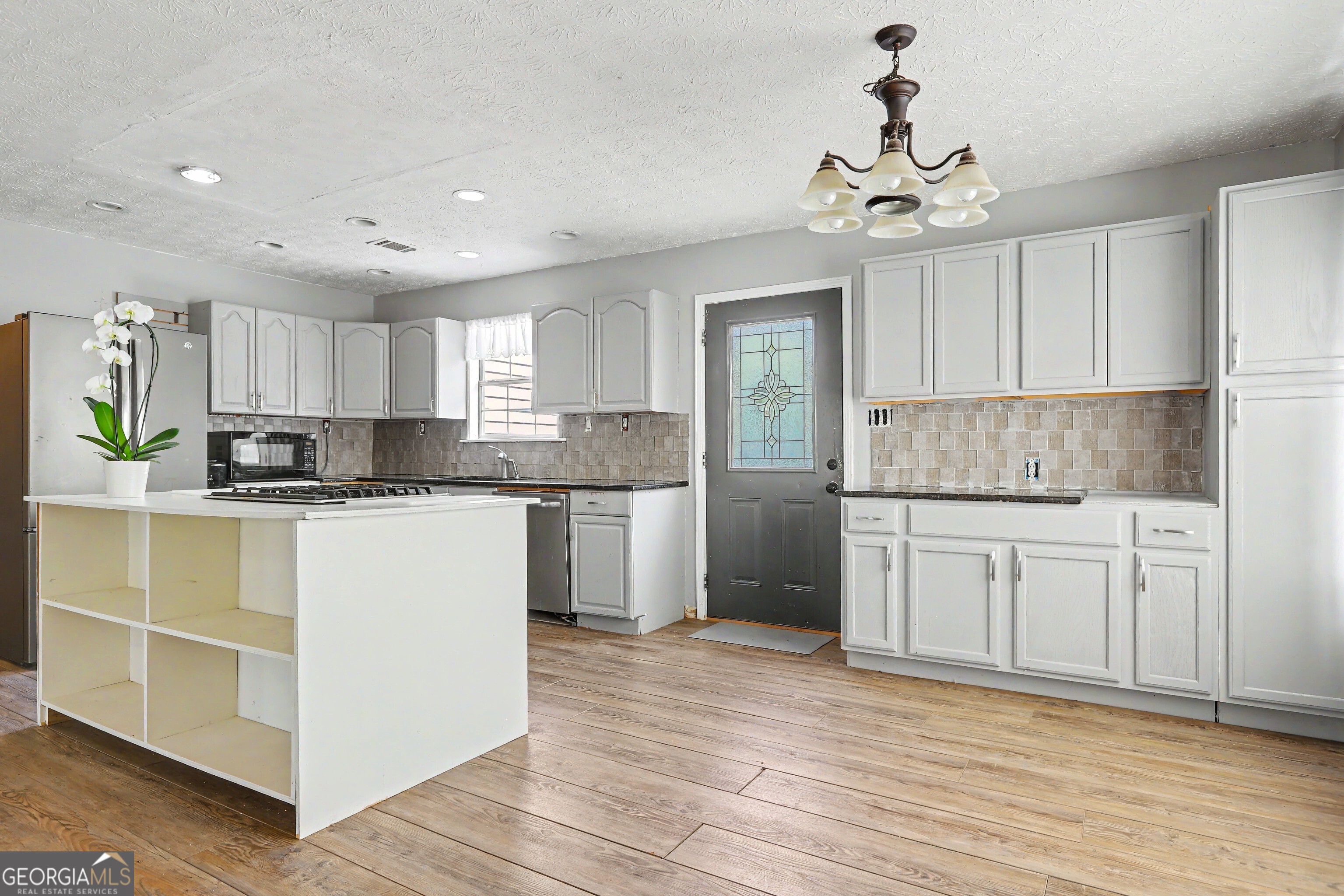 376 Doe Lane Mansfield, GA 30055 - Photo 8 of 28 a kitchen with kitchen island granite countertop a sink cabinets and stainless steel appliances