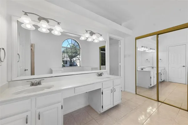 a spacious bathroom with a granite countertop sink a large mirror and a