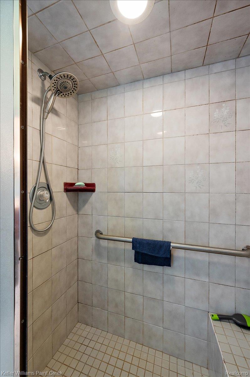 69069 Campground Road Romeo, MI 48065 - Photo 50 of 78 Tiled shower with a circular overhead light and a handheld showerhead