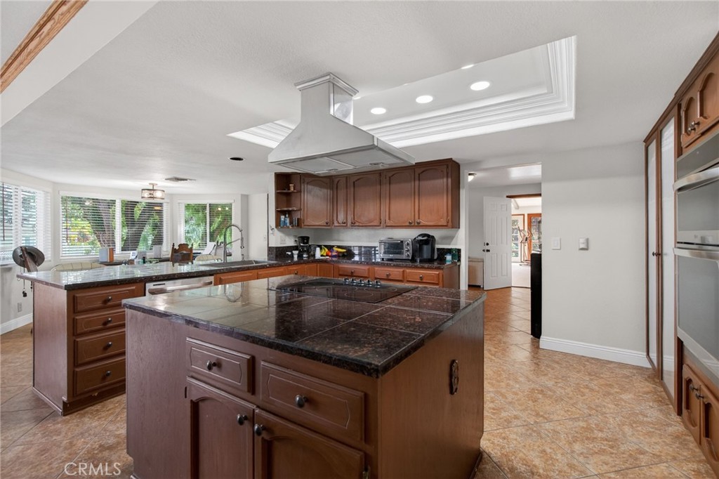 14435 Wood Road Riverside, CA 92508 - Photo 11 of 66 a kitchen with kitchen island granite countertop a sink a counter top space and stainless steel appliances