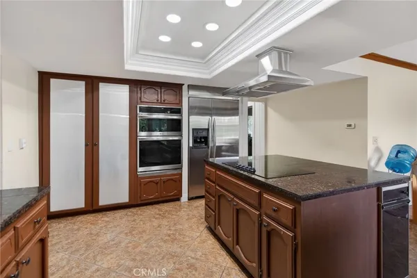 a kitchen with stainless steel appliances granite countertop a sink and a refrigerator