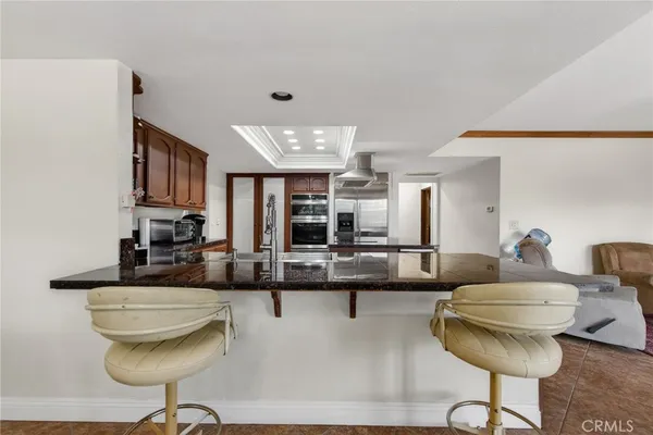 a living room with stainless steel appliances kitchen island granite countertop a dining table and chairs with wooden floor