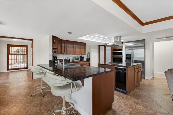 a kitchen with stainless steel appliances granite countertop a sink a stove and a refrigerator
