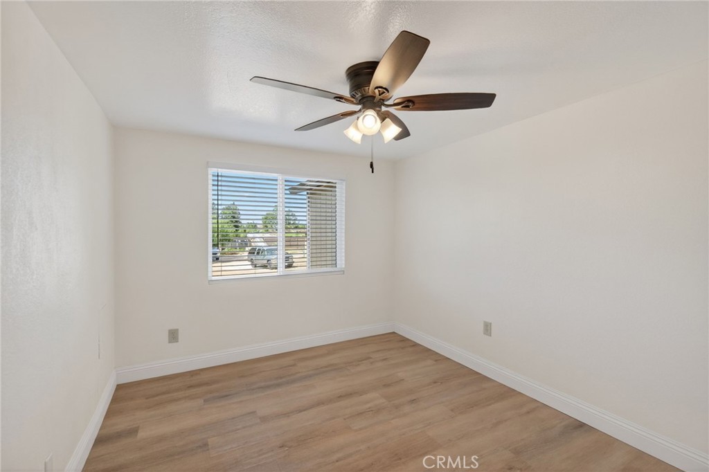 14435 Wood Road Riverside, CA 92508 - Photo 15 of 66 an empty room with wooden floor fan and windows