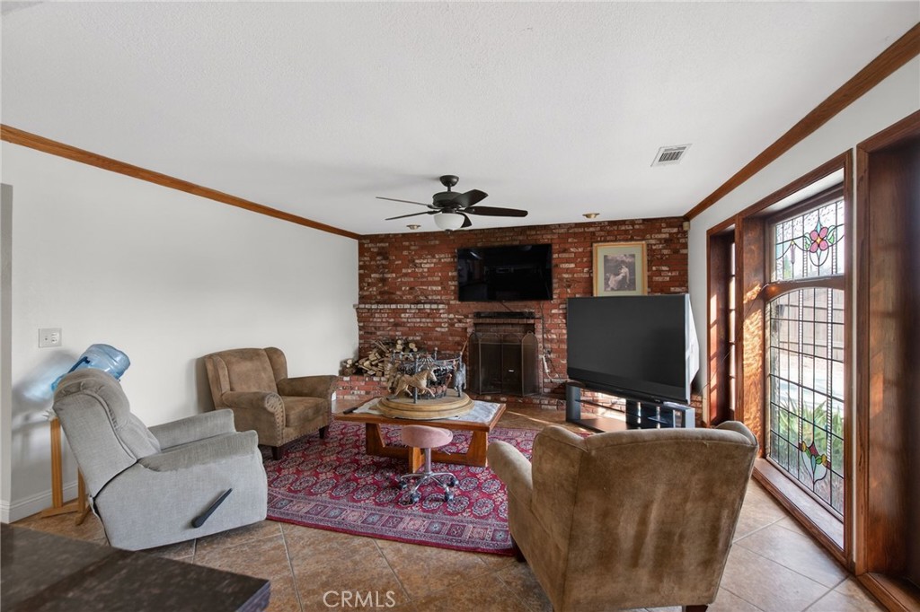 14435 Wood Road Riverside, CA 92508 - Photo 16 of 66 a living room with furniture a flat screen tv and a fireplace