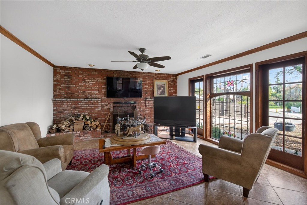 14435 Wood Road Riverside, CA 92508 - Photo 17 of 66 a living room with furniture a fireplace and a flat screen tv